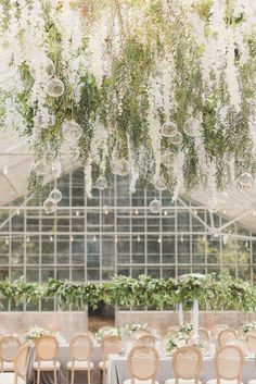 an indoor wedding reception with chandeliers hanging from the ceiling