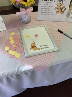 a baby shower is set up on a table with flowers and greeting cards in vases