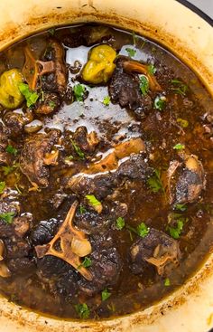 a pot filled with stew and vegetables on top of a stove burner, ready to be cooked