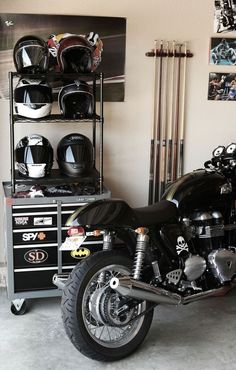 a motorcycle parked in a garage next to a shelf with helmets on top of it