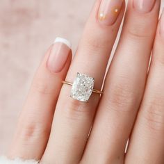 a close up of a person's hand with a ring on their finger and a diamond in the middle