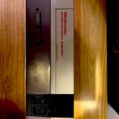 a vending machine sitting on top of a counter next to a wooden wall with writing on it