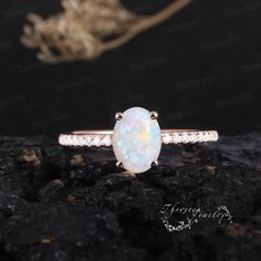 a white opal ring on top of a rock