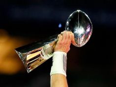 a close up of a person holding a trophy in the air with one hand and two other hands