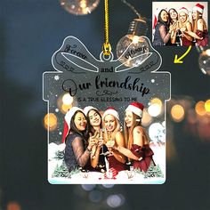 a christmas ornament hanging from a string with three girls holding champagne flutes and smiling