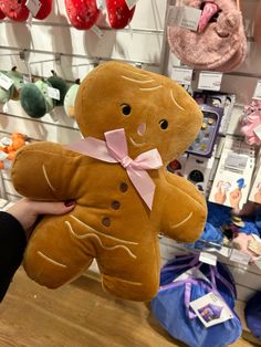 a person holding a large teddy bear in front of a store display with other stuffed animals