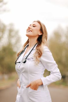 a woman wearing a white lab coat and stethoscope standing in the street