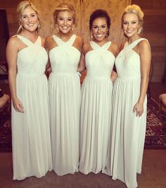 three women in white dresses standing next to each other