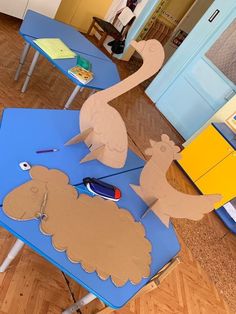 a blue table topped with cut out animals