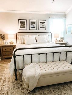 a bedroom with a white bed and two framed pictures on the wall above it's headboard