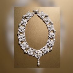 Complete your elegant bridal look with this exquisite White Tatting Lace Choker. This Victorian-style beauty is a one-of-a-kind piece of unique jewelry that will make a statement on your special day. The delicate lace choker features intricate details and a timeless design that is sure to wow everyone as you walk down the aisle. Add a touch of vintage charm to your wedding ensemble with this Frivolite Collar that exudes romance and sophistication. Elevate your bridal style with this stunning Vic Elegant Lace Wedding Choker, Wedding Choker Necklace White Lace, Elegant Lace Choker With Lace Trim, Wedding Choker Necklace, White Choker Necklace, White Lace Choker, Victorian Lace Choker, White Choker, Lace Choker Necklace