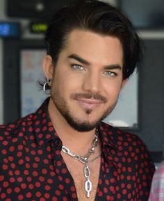 a close up of a person wearing a shirt and chain around his neck with an earring