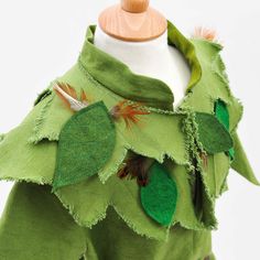 a green dress with leaves and feathers on it