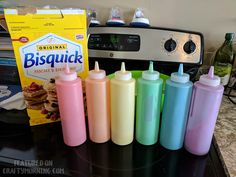 six different colored condiments sitting on top of a counter next to a microwave