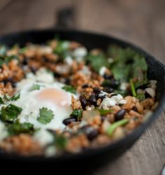 a skillet filled with rice, black beans and an egg on top of it