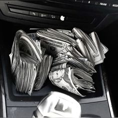 a pile of money sitting in the center console of a car