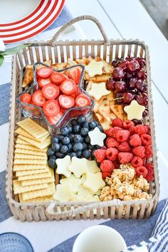 a basket filled with fruit and crackers on top of a table