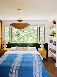 a bedroom with a large bed and lots of windows