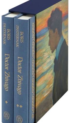 two books with paintings on them sitting next to each other