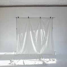 an empty room with a white curtain hanging from the ceiling