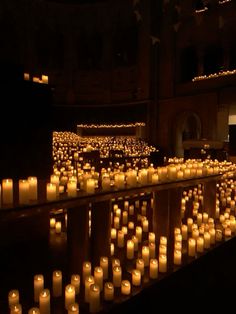 rows of lit candles in a dark room