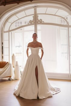 a woman in a white wedding dress posing for the camera