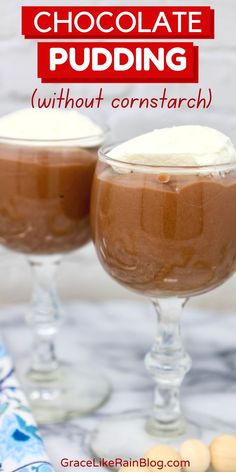 two glasses filled with chocolate pudding sitting on top of a table next to each other