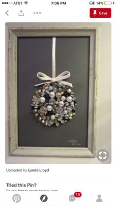 a framed christmas ornament hanging in a frame with a ribbon on the front