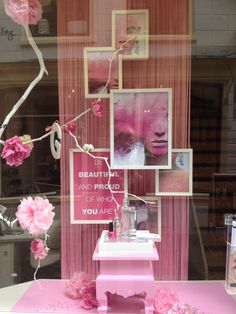 a display window with pink flowers and pictures on it