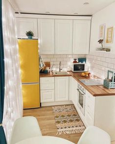 a kitchen with white cabinets and yellow refrigerator freezer next to a counter top oven