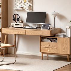 a wooden desk with a computer on top of it next to a chair and bookshelf