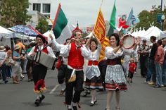 some people are walking down the street with flags and instruments in their hands as they dance