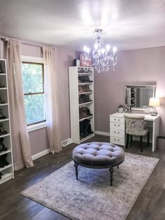 a bedroom with a chandelier, dresser and bed in the middle of it