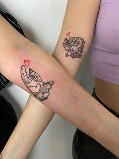 two people with matching tattoos on their arms, one has a cat and the other has a dog