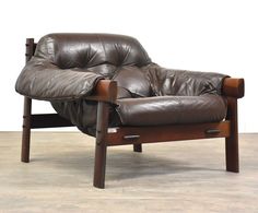 a brown leather chair sitting on top of a hard wood floor