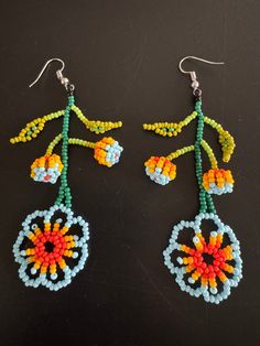 Here we have a beautiful pair of Floral hand crafted earrings! Traditional Flower-shaped Earrings With Ear Wire, Traditional Handmade Dangle Flower Earrings, Unique Flower Shaped Single Earring, Unique Single Flower Earring, Artisan Dangle Flower Earrings, Handmade Green Dangle Flower Earrings, Handmade Flower Chandelier Earrings Gift, Handmade Multicolor Bohemian Clip-on Earrings, Handmade Unique Beaded Earrings