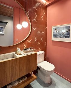 a bathroom with a sink, mirror and toilet in the corner next to a painting on the wall