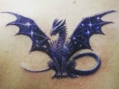 the back of a woman's stomach with an intricate dragon tattoo on her chest