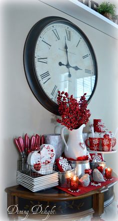 a large clock on the wall above a table with christmas decorations and other holiday items