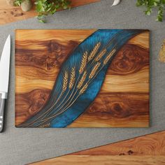 a knife sits next to a cutting board with an image of wheat and leaves on it