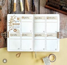 an open planner book sitting on top of a wooden table