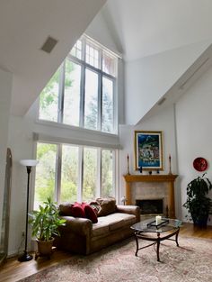 a living room filled with furniture and a fire place in front of a large window