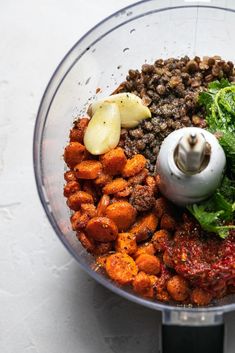 a food processor filled with meat, vegetables and other things to make it into a meal