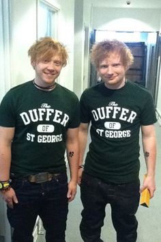 two young men standing next to each other in front of a mirror wearing green shirts