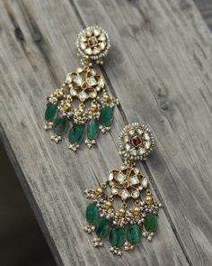 Handcrafted in gold, this pair of earrings hold an elaborate floral unit studded with uncut diamonds/polki suspended from the top, finished with pearls and pink tourmaline/green emerald drops, with just a hint of red. Estimated Details :Gold(22K) : 5.49gGold(18K) : 20.89gUncut diamonds/Polki : 2.21ctTourmaline/Emerald : 24ct(The above weights are indicative)Note: If the design is not readily available it will be made to order, which will take us approximately 30-45 days. Vintage Indian Jewelry, Chand Bali, Kundan Jewellery Set, Polki Earrings, Antique Jewellery Designs, Lifestyle Ideas, Traditional Earrings