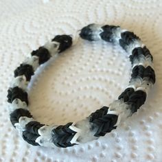 a black and white braided bracelet sitting on top of a bed