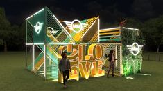 two people are standing in front of an illuminated sign that says go live at night