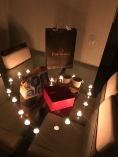 a table that has some candles on it and a bag in the middle with lights around it