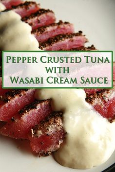 a white plate topped with meat covered in gravy next to a green sign that says pepper crusted tuna with wasabi cream sauce