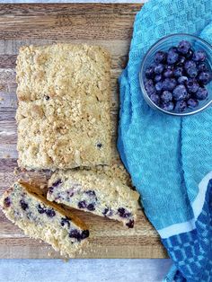 a wooden cutting board topped with blueberries next to a bowl of oatmeal